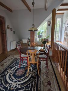 a dining room with a table and chairs on a rug at Molas svečių namai in Klaipėda
