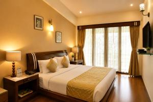 a hotel room with a bed and a window at Hotel Shiv Shakti in Rajkot