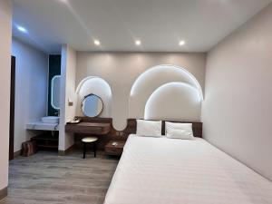 a bedroom with a bed and a sink and mirror at Hidden Green Hotel Tam Coc in Vũ Lâm +68 photos