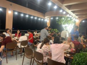 a group of people sitting at tables in a room at Hidden Green Hotel Tam Coc in Vũ Lâm