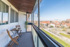 ein Balkon mit einer Bank und Blick auf eine Stadt in der Unterkunft Borca 3 in Borča