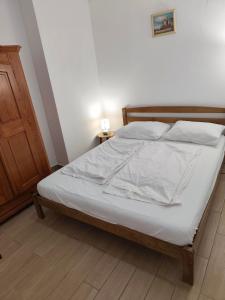 a bed with white sheets and pillows in a bedroom at Apartment Batomalj in Baška