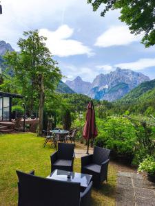 a patio with a table and chairs and mountains at Apartments Smolej Kranjska Gora in Kranjska Gora