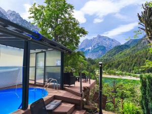 a house in the mountains with a swimming pool at Apartments Smolej Kranjska Gora in Kranjska Gora