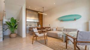 a living room with a couch and a surfboard on the wall at Surfside Uluwatu Resort in Uluwatu