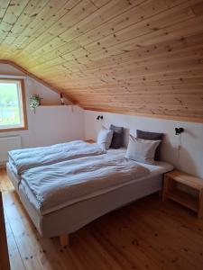 ein großes Bett in einem Zimmer mit Holzdecke in der Unterkunft Arctic Ranch in Överkalix