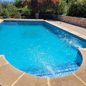 a swimming pool with blue water in a yard at Cortijo La Joya in Lanjarón