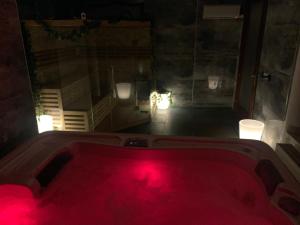 a bath tub with red lights in a bathroom at Várfal Panzió és Wellness in Pécs