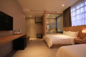 a hotel room with a bed and a television at Hangkhau Hotel in Yilan City