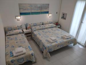 a hotel room with two beds and two chairs at Residence BluAdria in San Mauro a Mare +37 photos