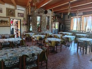 a restaurant with tables and chairs with green table cloth at agriturismo heaven in Capo Vaticano