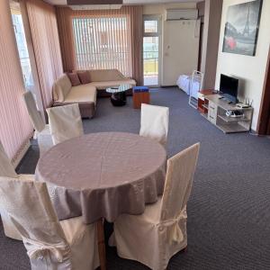 a living room with a table and chairs at Family Hotel Diana in Pomorie