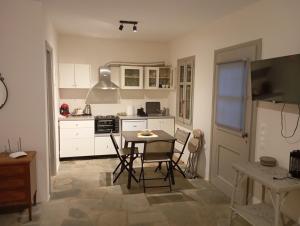 a kitchen with white cabinets and a table and chairs at Blue Agave in Agios Sostis