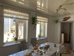 a dining room with a table and some windows at Guest House Eltin in Bokonbayevo