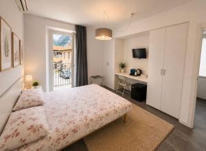 a bedroom with a bed and a desk and a window at VILLA CHIARA Lago Maggiore in Gravellona Toce