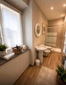 a bathroom with a sink and a toilet and a window at VILLA CHIARA Lago Maggiore in Gravellona Toce