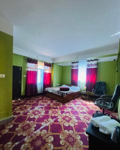 a bedroom with a bed and red curtains and a carpet at The Mirik Address in Mirik