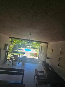 a room with a table and chairs and a swimming pool at Infinity by the River in Kumanovo
