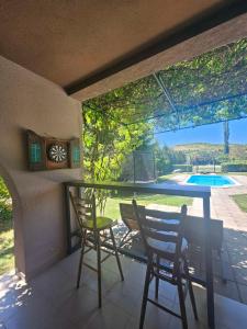 a porch with two chairs and a table and a clock at Infinity by the River in Kumanovo