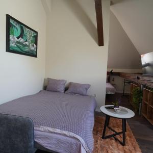 a small bedroom with a bed and a table at Elidon 1833 in Pančevo