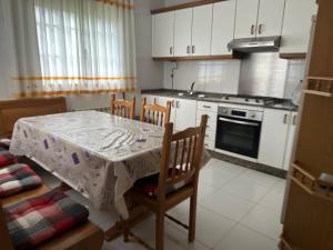 a kitchen with a table and chairs and a stove at Refugio Rural A Revolta in Bergazo +15 photos