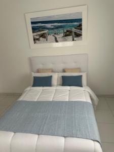 a bed in a bedroom with a picture of the beach at Refugio Rural A Revolta in Bergazo