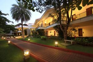 einen Innenhof eines Gebäudes mit Lichtern im Gras in der Unterkunft Silent Shores Resort & Spa in Mysore