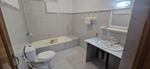 a white bathroom with a toilet and a sink at Basera Lodges in Nathia Gali +28 photos