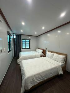 two beds in a room with two beds sidx sidx sidx sidx sidx at ILLUMI Homestay in Dong Hoi +3 photos