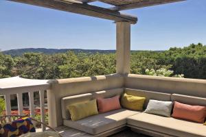 a porch with a couch with pillows on it at La Villa Les Petits Gardons in Castillon-du-Gard