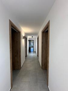 an empty hallway with wooden doors and tile floors at Cabana LoSt Ventoc in Vulcan +40 photos