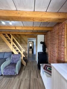 a living room with a couch and a brick wall at Cabana LoSt Ventoc in Vulcan