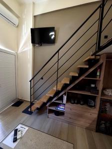 a living room with a staircase with a tv on the wall at Loft 73 in Kalamata