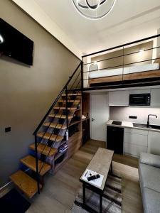 a living room with a staircase and a kitchen at Loft 73 in Kalamata +4 photos