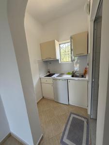 a small kitchen with white cabinets and a window at Green House in Himare