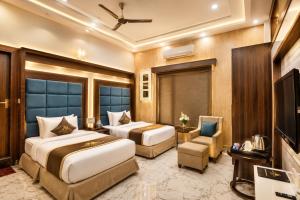 a hotel room with two beds and a television at Taj View By Signature Stayz in Agra