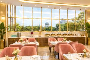 a restaurant with tables and chairs and large windows at Taj View By Signature Stayz in Agra