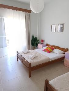 a bedroom with a bed and a large window at Canvista in Leptokarya