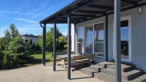 a porch with a bench on the side of a house at Vieno aukšto kotedžas in Šventoji