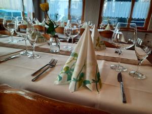 a table with a white table cloth with wine glasses and napkins at Hotel Schiffahrt in Mols