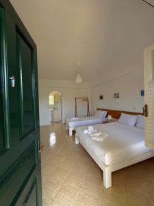 a large room with two beds and a door at Green House in Himare
