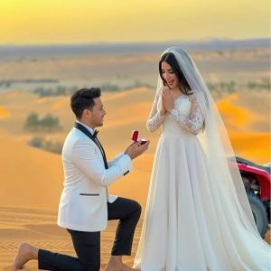 a bride and groom taking a picture in the desert at Nour Desert Luxury Camp in Merzouga
