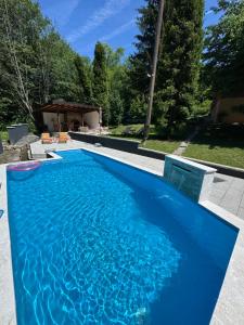a swimming pool with blue water in a backyard at Maca - vikendica sa bazenom in Ahatovići +26 photos