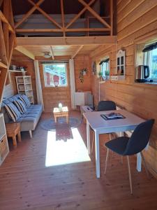 ein Wohnzimmer mit Tisch und Stühlen in einer Hütte in der Unterkunft Arctic Ranch in Överkalix + 95 Fotos