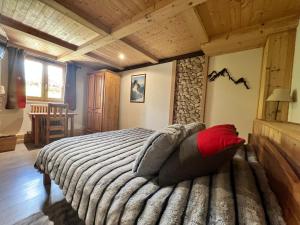 a bedroom with a large bed with red pillows at Chalet l'Aiglon in Saint-Gervais-les-Bains