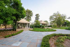 a garden with a pavilion and a walkway at Orchard At Sarai - Luxury Tent Villas, Swimming Pool, Large lawns, & Pet friendly in Gurgaon