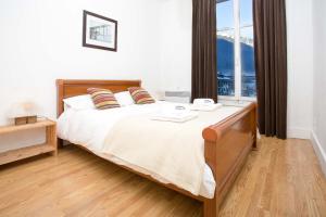 Un dormitorio con una cama grande con una ventana grande. en Mont Blanc 98 Apartment - Chamonix All Year, en Chamonix-Mont-Blanc
