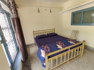 a bedroom with a bed in a room with a window at Leela's Abode in Bhowāli +3 photos