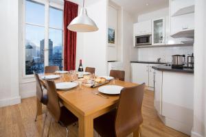 Una cocina y un comedor con mesa y sillas de madera. en Mont Blanc 98 Apartment - Chamonix All Year, en Chamonix-Mont-Blanc