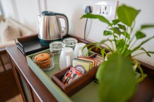 a table with a tea kettle and a plant on it at Orchard At Sarai - Luxury Tent Villas, Swimming Pool, Large lawns, & Pet friendly in Gurgaon